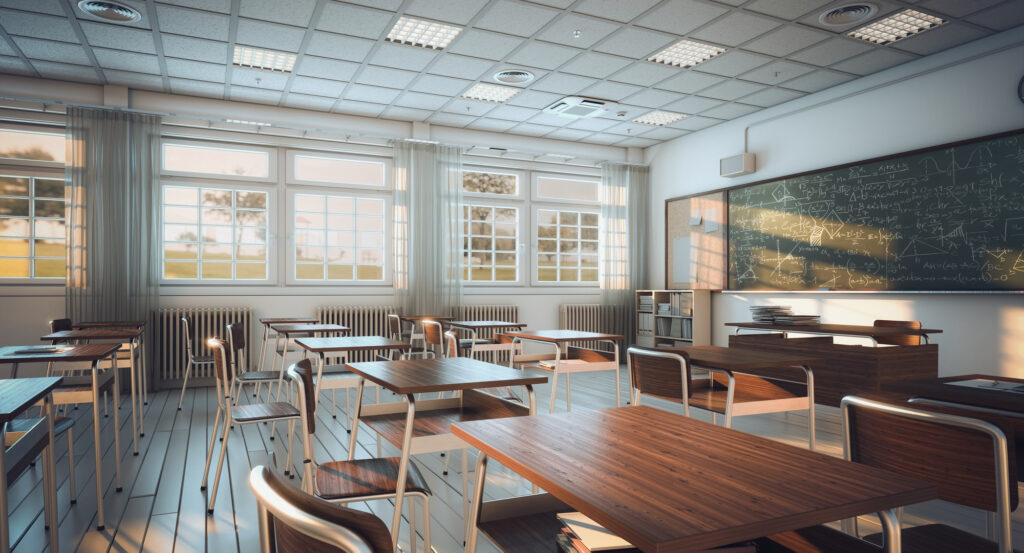 A classroom with rows of desks and chairs facing a chalkboard.